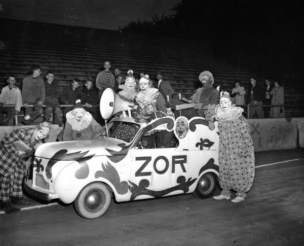 A group of clowns posing with their small car during the annual Knights of Columbus-Zor Shrine show at Breese Stevens Field.