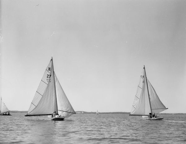 View across water towards two Madison boats that will participate in the Inland Lakes Regatta to be held on Lake Mendota. At the left is "Coro," owned by Cornelius Browne and Robert Sweet. At the right is "Redskin," owned by Jack Bolz.