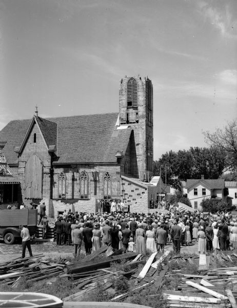 A crowd gathers for the cornerstone dedication ceremony of the new reconstructed Norway Grove Lutheran church in DeForest. The present DeForest Lutheran church is depicted in the background. The original Norway Grove church was moved to its present site from its old site in Vienna Township. When completed, the two buildings will be linked architecturally.