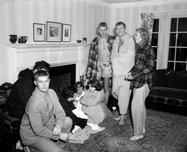 Eight University of Wisconsin summer students warming themselves in the Henry Schuette residence at 719 Farwell Drive, following a boat accident in which 22 U.W. students were involved. Left to right: Don Setzkorn, Marshfield, Wisconsin; Avery Kessler, Marion Videa, Marianna Flowers and Deirdra Burke, New Orleans, Louisianna; Marc Kremmers, Wauwatosa, Wisconsin; Merton Hillyer, Sheboygan, Wisconsin; and Lynn Baker, Oak Park, Illinois.