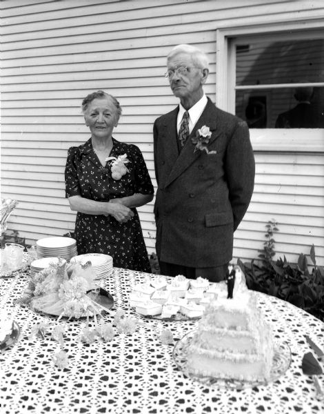 Portrait of Frank M. and Helen Meyer of 132 Franklin Avenue standing by their dining room table during an open house celebrating their golden wedding anniversary.