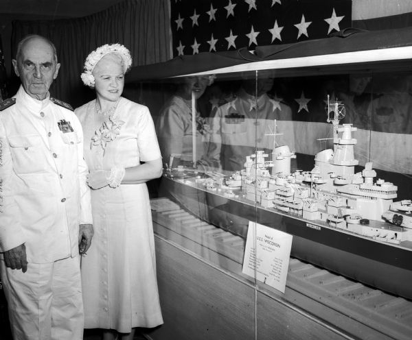 Fleet Admiral William D. Leahy, left, and Mrs. Oscar (Mary) Rennebohm, Wisconsin's first lady, stand next to a ten-foot model of the Battleship USS "Wisconsin" on display at the State Historical Society museum. The miniature of the battleship was made by E.R. Wendelberg of Milwaukee.