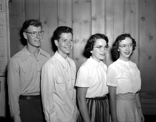 Four Madison high school graduates awarded University of Wisconsin music scholarships at the Summer Music Clinic posing against a wood-paneled wall for a portrait. From left are: Jeremy Fox, Stanley Stitgen, Betty Casida, and Beth Mitchell.
