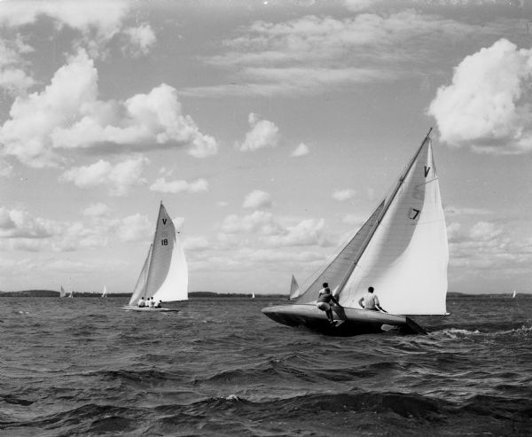 Class A and Class E sailboats are shown maneuvering to round a buoy in strong wind during one of the races of the 49th Annual Regatta of the Inland Lakes Yachting Association.