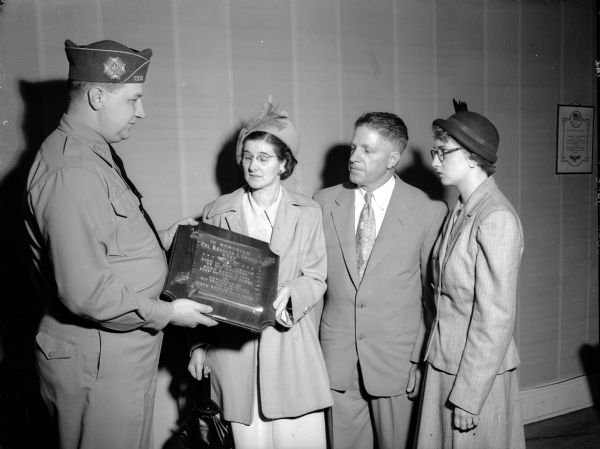 A memorial plaque in honor of Corporal Kenneth Grosse was presented to the air force man's parents, Mr. and Mrs. Carl Grosse, center, and their daughter, Patricia, right, by the commander, Donald Cowan Sr., of the Madison Veterans of Foreign Wars (VFW). Corporal Grosse drowned in Newfoundland in 1949.