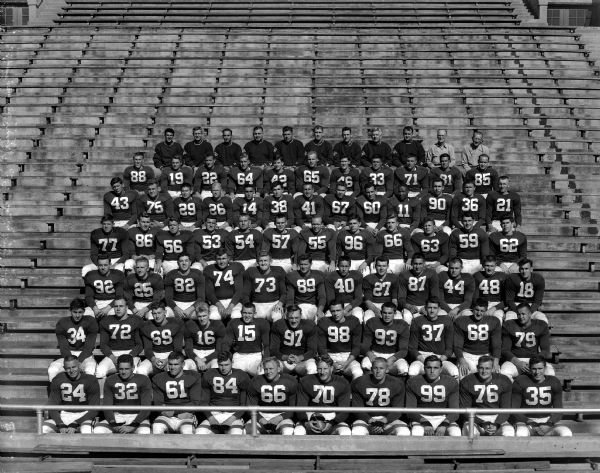 The University of Wisconsin football squad sitting in the stands at Camp Randall stadium for a group portrait.