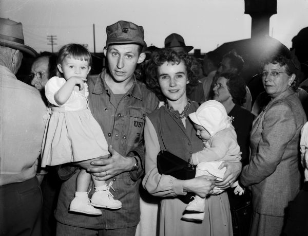 Marine Pfc. Russell J. Seldal, a member of the Madison marine reserve unit being sent to Korea, holds his daughter Elaine while his wife, Betty, holds their son David.