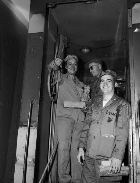 Three members of the Madison marine reserve unit board a train for duty in Korea. From left to right are: Capt. J.J. Warner, Capt. John Jensvold, and Lieut. Fred Goff.