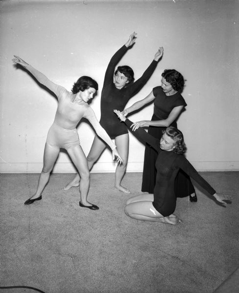 Marjorie Muehl Parkin, far right, is the instructor for the modern dance class at the YWCA.  She also teaches at the University of Wisconsin. She is shown with three of her students, teaching them a "line design." Left to right are Mrs. Dale W. Eikenberry, 1809 Madison Street; Mrs. Milton (Sonia) Greenberg, 317 Lake Street and Miss Lucille Frederick, 2 Landon Street, kneeling.