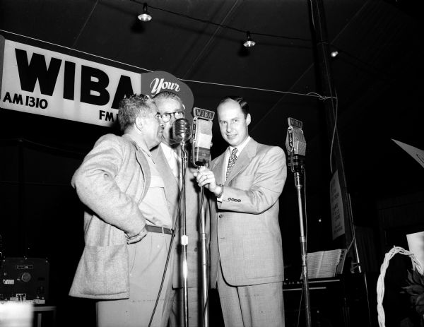 Three men standing at the microphone during a WIBA Radio broadcast from the Madison Home Show.