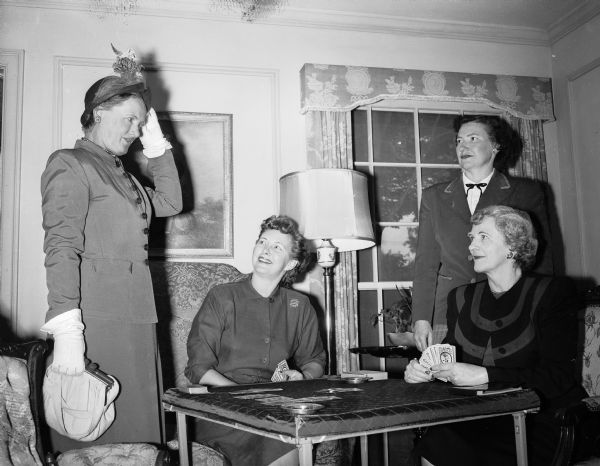 Four League of Women Voters of Madison members who will perform a skit, "Bridge a la League" at a membership reception, are gathered around a card table. From left are: Mrs. Frank (Alnora) Lathers, Mrs. Frank K. (Gladys) Dean, Mrs. Thomas J. (Rosamond) Doran, and Mrs. William (Mabel) Lewis.