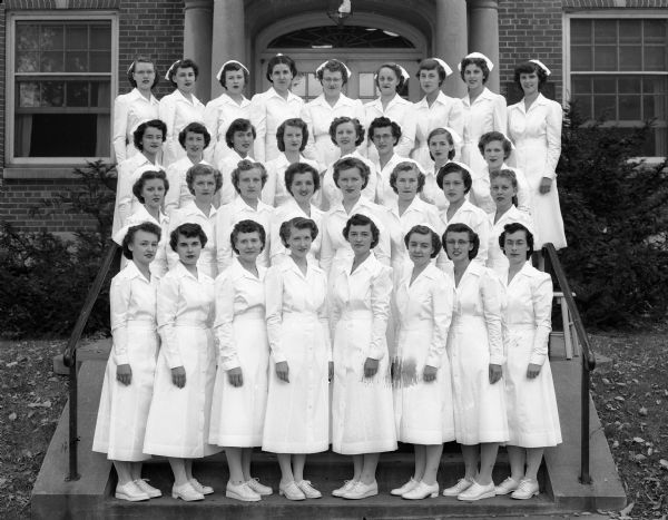 The graduating class of nurses at the school of nursing at Madison General Hospital (Meriter) gathers on a set of stairs for a group portrait.