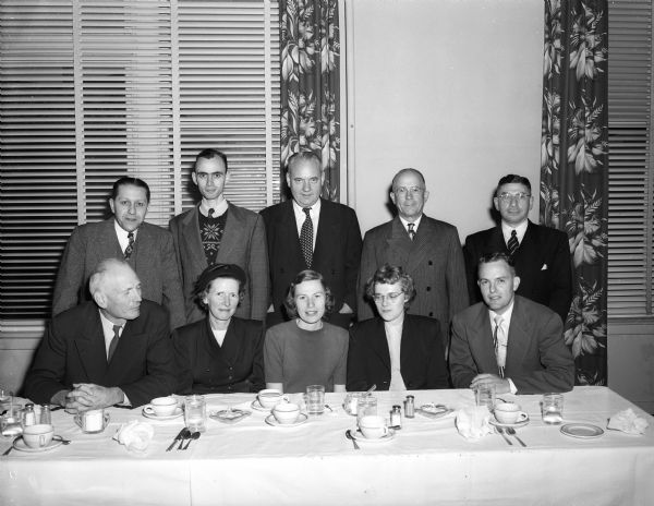 Members of the teaching staff of the Madison Inter-Church Leadership Training School gather around a table at a luncheon meeting. Seated, from left, are: Rev. George L. Collins, Baptist Student Center; Louise Triplett, director of Christian education, State Congregational Conference; Mrs. Robert Adams, West Side Community Methodist Church, Mrs. W.L. Burton, education director, Christ Presbyterian Church; and Rev. Allen P. McCaul, associate minister, First University Methodist Church, and dean of the school. Standing, from left, are: Rev. Charles A. Puls, pastor, Luther Memorial Church; Rev. Robert Adams; Rev. Fred M. Smith, board of education, West Wisconsin Conference, Methodist Church; Charles N. Perrin, Christ Presbyterian Church; and Rabbi Manfred Swarsensky, Temple Beth El.