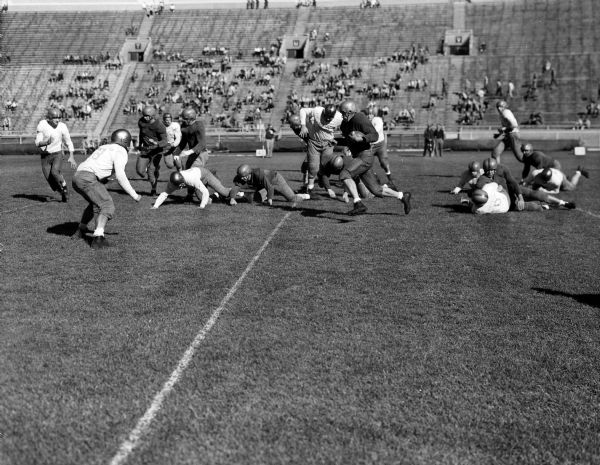 University of Wisconsin intra-quad football game, showing halfback Bob Mansfield running with the ball.