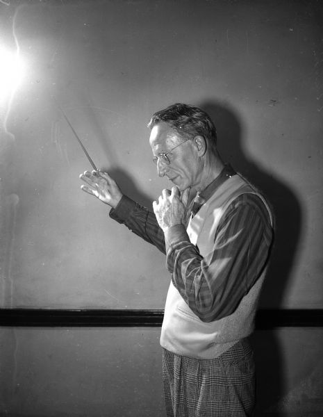 Walter Heermann, conductor of the Madison Civic Symphony and Civic Chorus, poses with a baton in his hand.