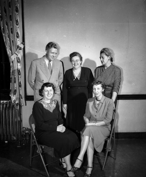 Madison Civic Chorus members to participate in performance of The Messiah posing for a group portrait. They are, from left to right: (standing) Ralph James, assistant conductor; Louise Morrissey; Elizabeth Hunter and (seated) Mrs. Robert (Grace) Schumpert and Helen Jansky.