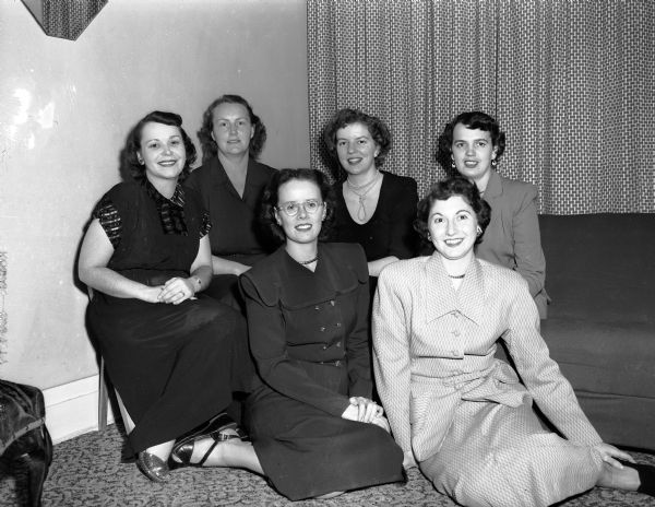 New officers of the University of Wisconsin Dames Club pose for a group portrait. Seated are: Mrs. Richard Mullineaux (left) and Mrs. Ralph Smuckler. In back, left to right, are: Mrs. Robert Swick, Mrs. Lester Morrissey, Mrs. LeRoy Dietrich, and Mrs. Frederick J. Simpson.