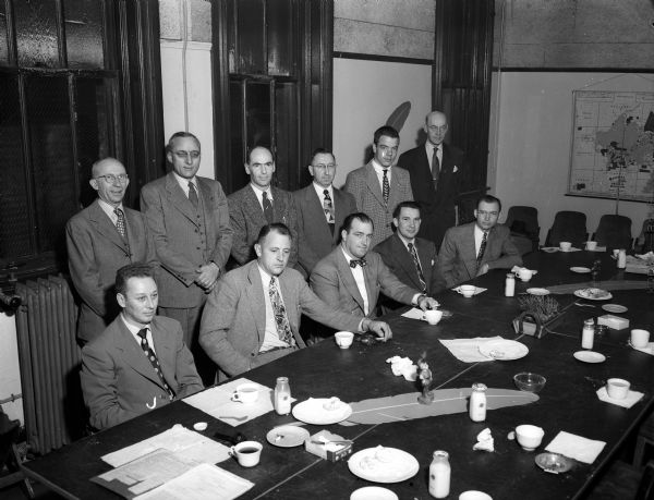 Group portrait of the volunteer workers of the United Givers' Fund at their planning meeting for solicitation of business and industrial firms for their annual fund raising drive. Seated left to right: Leonard Couture, Strand Baking Company; Harold Habeck, Bancroft Dairy Company; Frank Johnson, Midwest Insurance Agency; Gordon Bakke, Rennebohm Drug Company; and Ray Devine, Manufacturers and Merchants Indemnity Company. Standing left to right: Joe Bauhs, Kennedy Mansfield Company; John Wrage, business and industrial division chair; Russell Dymond, Red Dot Foods, food section chair; Eugene Downey and Eugene Gugel Chocolate Shop; and Foster E. Blackburn, Simon Brothers.