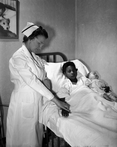 Nurse Sadie Zum Brunnen tends to a patient, seven-year-old Bonita Gill, at Madison General Hospital. Sadie is a member of the Madison Business and Professional Women's Club which is celebrating National Business Women's Week.