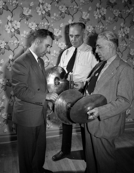 Portrait of Madison VFW Drum and Bugle Corps officials holding cymbals.  They are, from left, Gilbert Dennis, musical director; A.J. Taff, corps president, and Galen Day, color bearer.