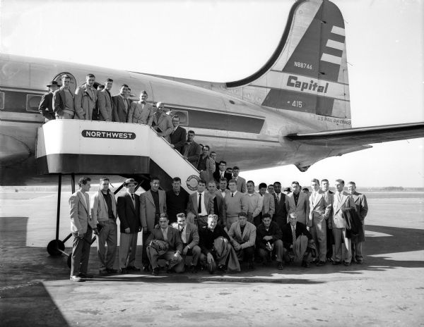 The University of Wisconsin football team boards an airplane taking them to their game at Michigan, played the following day.