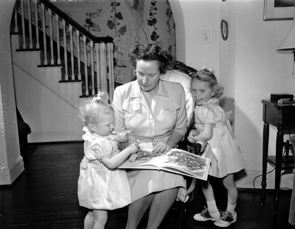 Mrs. Carl S. (Doris) Harper of 3 Cambridge Road is pictured with her two granddaughters, Susan, age one and a half (left), and Catherine, three and a half, (daughters of the junior Carl S. (Ann) Harpers, of Santa Fe, New Mexico who are visiting Madison relatives with their parents. The junior Mrs. Harper is the former Ann Jackson, daughter of Dr. James A. Jackson, Fox Bluff.