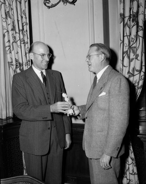 Oscar Gustave Mayer, left, campaign chairman of the first Madison United Givers' Fund campaign, presents a Red Feather award to Claude Bell, United Givers' Fund solicitation chairman at the Forest Products Laboratory.