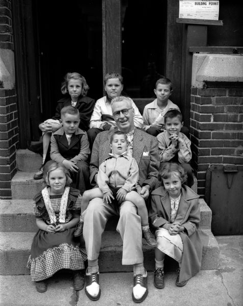 A group of children held a fund raising circus at the corner of Memphis Avenue and Webb Avenue to aid Roundy's Fun Fund which aids handicapped children. First row: Patsy Crapp and Charlene Shelton. Second row: Tommy Torbeau, Roundy (Joseph Coughlin) holding Ricky Gotzion and Jimmy Gotzion. Top row: Judy Shelton, Buster Crapp and Gary Gotzion.