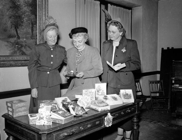 The Zor Shriner Auxiliary Christmas and greeting card project is one of the best fund raising activities to benefit Shriners' hospitals for crippled children. Pictured left to right admiring some of the cards on display are: Mrs. A.R. (Pearl) Jennings, 2901 Monroe Street, Zor auxiliary president; Mrs. Archie F. (Rosalind) Johnson, 402 Paunack Place, chairman of the card committee, and Mrs. C.M. (Leeta) Howard, 4154 Nakoma Road, "Sunshine" chairman, who sends cards to ill and hospitalized members.