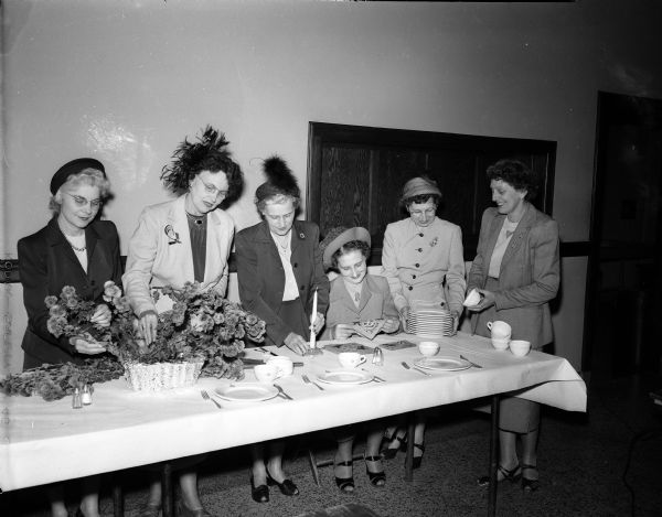The Zor Shriner Auxiliary luncheon and dinner meetings are some of the group's fund raising activities. Decorations and floral arrangements are sold to members to raise money for the Shriners' hospitals for crippled children. Pictured preparing for one of the luncheons are, left to right: Mrs. O.E. (Ethel) Gibson, 433 South Owen Drive; Mrs. R.E. Lindberg, Edgerton; Mrs. S.D. (Ernestine) Swartz, 701 Chapman Street; Mrs. R.R. (Anetha) Schultz, 613 Crandall Street; Mrs. H.L (Esther) Erickson, 2132 East Dayton Street, and Mrs. Walter (Lucy) Haspell, 825 Minakwa Drive, chairman of the hospitality committee.