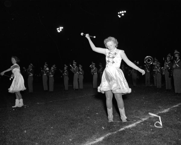 Two drum majorettes and members of the West High School band perform on the field at halftime of the football game against Kenosha at Breese Stevens Field.