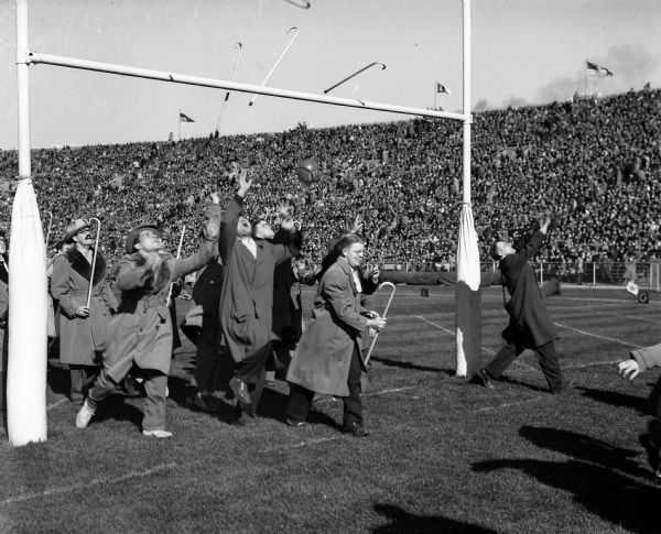 University of Wisconsin senior law students participate in the traditional ceremony of tossing their canes over the south goal post's bar at the homecoming football game between Wisconsin and Purdue. Tradition is that if they catch the cane on the other side they will win their first case in court.