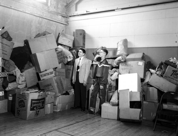 Dick Brilliott, left, and John Hudson, co-chairmen of the Madison Youth Clothes-for-Korea drive, eye the piles of clothing lining the halls of the Madison Community Center.
