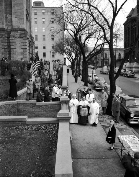 Slightly elevated view of a procession being led out of St. Raphael's Cathedral by Bishop William P. O'Connor in honor of the Madison Knights of Columbus 50th Anniversary.