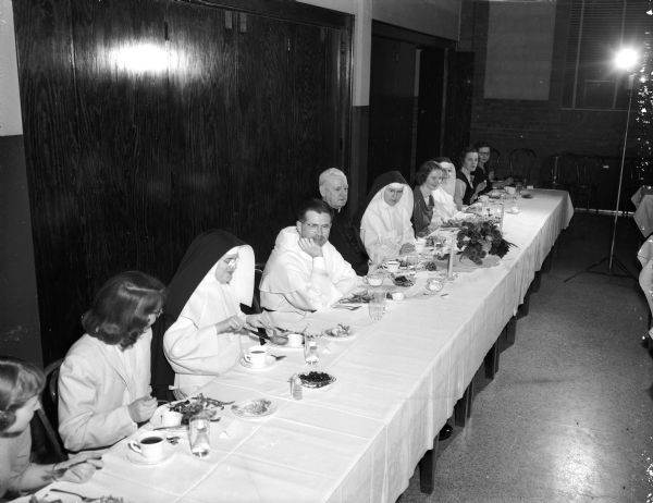 People sit around the head table for the annual college day for students at Edgewood College. From left are: Sister Mary Peter, O.P.; Rev. Mark Barron, O.P., chaplain of Edgewood college; guest speaker Rt. Rev. Msger. William Mahoney, rector of St. Raphael's cathedral and vicar-general of the Madison diocese; Sister Mary Nona, O.P. president of Edgewood College; Ann Marie Conway, Sioux Falls, South Dakota, president of the student association; Sister Jane Frances, O.P., college dean; Joanne Hughes, Columbus, president of the junior class; and Lois Hill, Galena, Illinois, vice-president of the senior class.