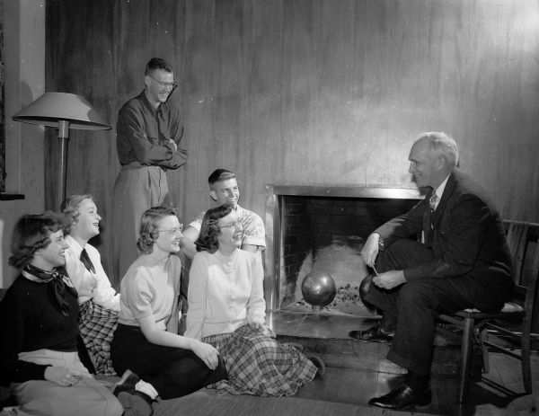 Professor Lowell E. Noland chats with members of the University YMCA and YWCA at a program of fireside chats. Seated are (left to right): Wanda Bertelman, Bettina Henel, Charlene Carlson, Beth Mitchell, and John Liesman. Standing is Carl Poole.