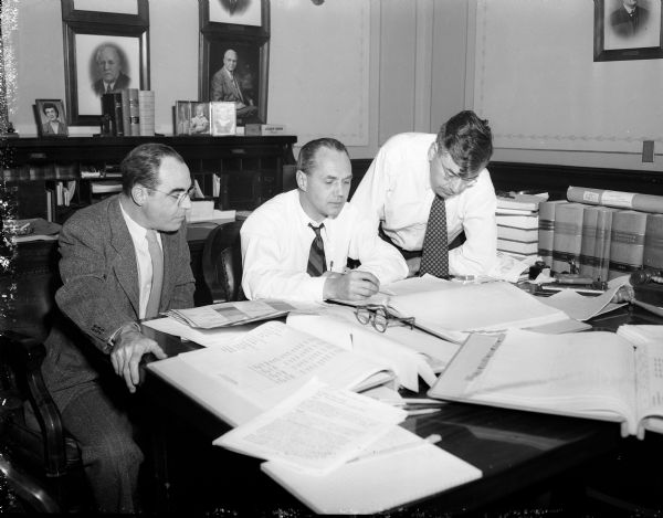 Governor-elect Walter J. Kohler works on his executive budget with State Auditor J. Jay Keliher (left) and Budget Director E.C. Giessel (right).