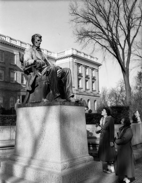 Two U.W. students, Jean Wall, Oshkosh, left, and Diane Cizon, Washington, D.C., standing before the Lincoln statue on the Lincoln Terrace in front of Bascom Hall.