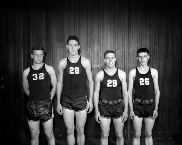 Members of the East High School Baseketball team posing for a group portrait in uniform. Left to right: Lloyd Hill, Charles Brendler, Ronnie Schara, and Davey Johnson.