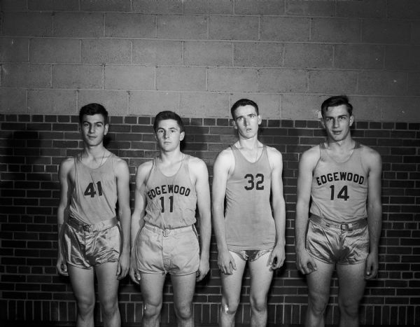 Four players of the Edgewood boy's basketball team, 1950-51 season, posing against a brick wall for a portrait. They are #11 Earl Ross; #14 Bill Schwoegler and two unnamed players wearing #41 and #32.