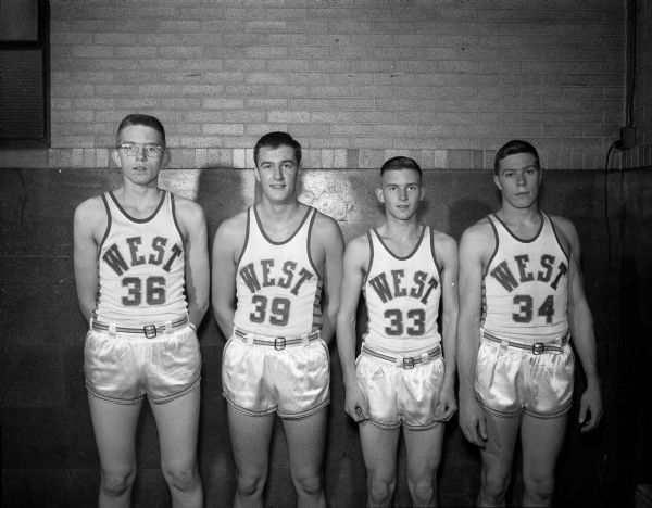 Group portrait of four unidentified Madison West High School basketball players.