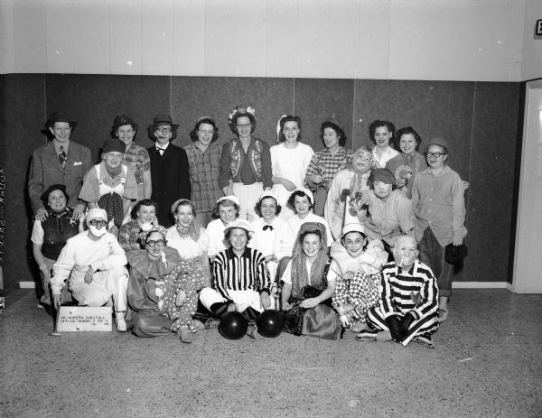 Group portrait of twenty-five costumed members of a girls' bowling team.