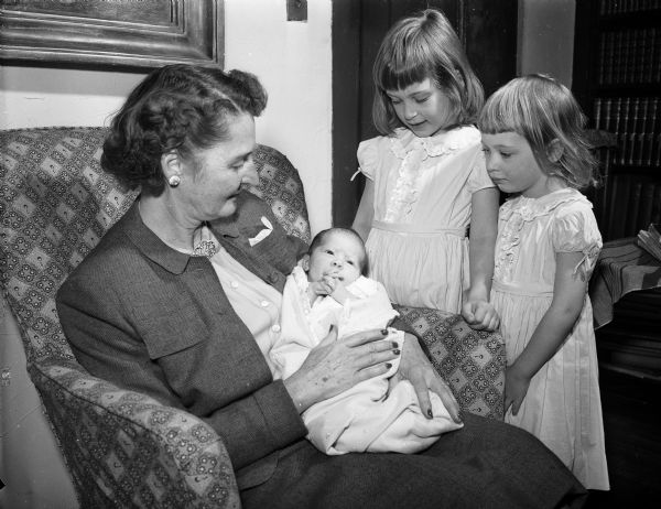 Mrs. H. Kent (Jeanette) Tenney of 1153 Farwell Drive spends time with  her three young granddaughters, Cornelia, two weeks (in her grandmother's lap), and standing left to right, Marion, five and a half, and Katherine, four. The girls are the daughters of Dr. and Mrs. Horace K. (Lucia) Tenney III, 2121 Adams Street. Young Mrs. Tenney is the former Lucia Rogers, daughter of Professor Samuel G.A. (Marion) Rogers, 2121 Adams Street.