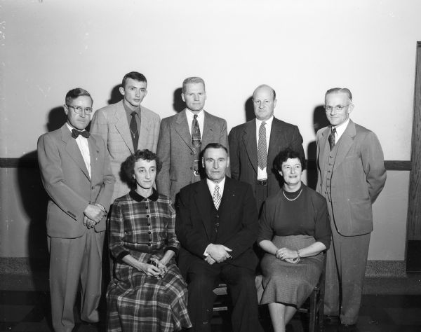 Group portrait of adult organizers and speakers for the banquet to honor West High School cross country runners. Front row, left to right: Mrs. Harry (Freda) Consigny, Tom E. Jones, and Mrs. Harold (Mildred) Mash. Back row: Leo Merkel, Tom Ward, Riley Best, Guy Sundt, and Harold R. Mash.
