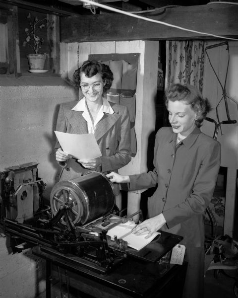 Mrs. George Linn and Mrs. C.L. Dillahunty run off copies of the "Damely News," a monthly newsletter for the Dames Club, a club for wives of University of Wisconsin students.