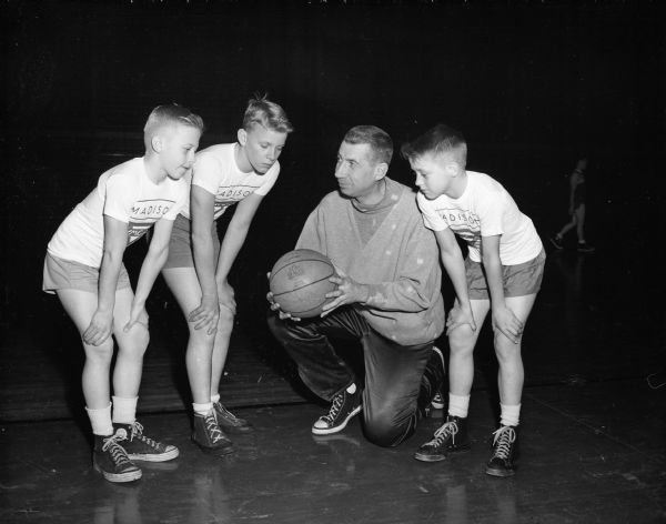 University of Wisconsin basketball coach Harold "Bud" Foster talks with three boys about the first annual YMCA boys basketball school. The boys are, from left: Bob Hillner, Billy Melby, and Jerry Peterson.