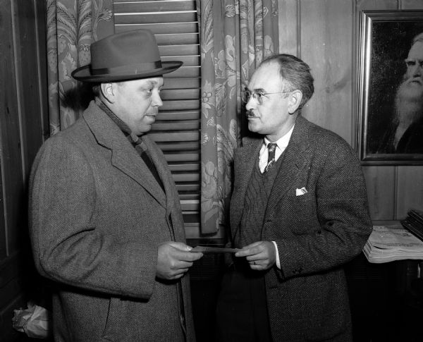 Herman G. Kleinheinz (left) of Madison Council Number 531 of the Knights of Columbus presents a check for $1,100 to William L. Doudna of the <i>Wisconsin State Journal</i> staff for the Empty Stocking Club.
