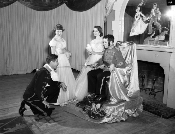 A scene from the "Emperor's Waltz" party at the Alpha Epsilon Pi Fraternity house. Portraying the emperor on the throne is Stanley Kritik, Milwaukee, and kneeling before him is Richard Holland, New York City. Standing are Lois Schwartz, Baltimore, Maryland, and Claire Schmitt, Milwaukee