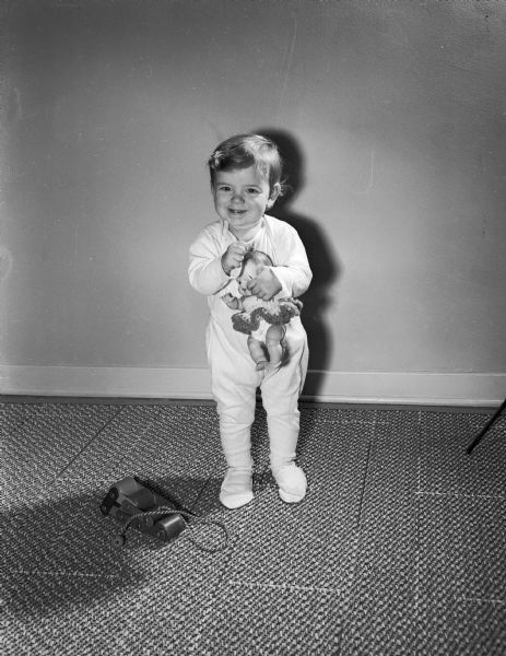 Young child holding a doll.  The image was taken to represent children helped by the Empty Stocking Fund.