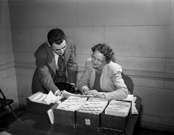 Mrs. Leslie (Luella) Morris and Allen Zoeller check for children's names in the "Holiday Exchange," a filing system which serves as a clearing house for the clients of all community welfare agencies.